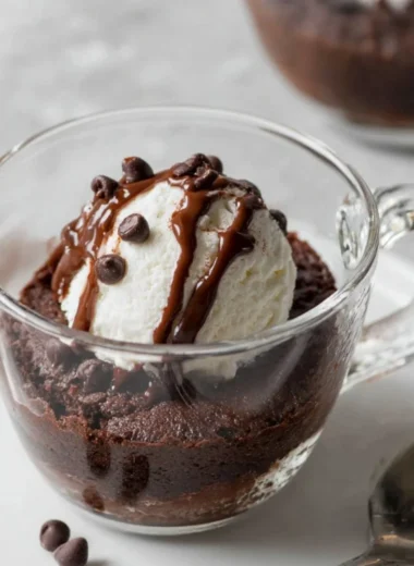 Fudgy brownie mug cake in a microwave-safe mug topped with chocolate chips.