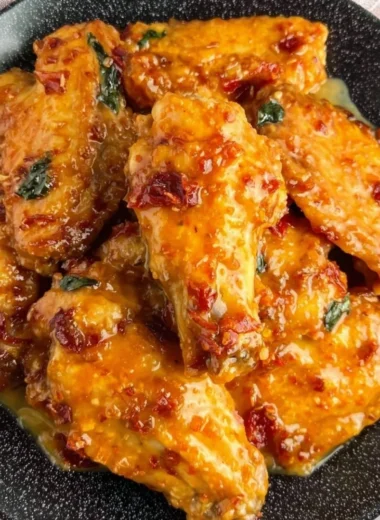 Plate of golden Honey Garlic Chicken Wings garnished with green onions