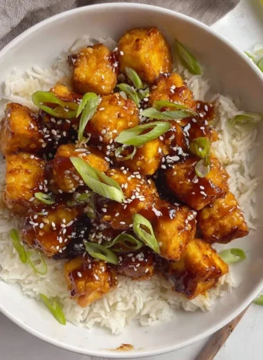 Plate of Honey Garlic Tofu garnished with green onions and sesame seeds.