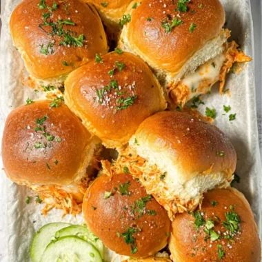 Plate of spicy Buffalo chicken sliders garnished with fresh ingredients.