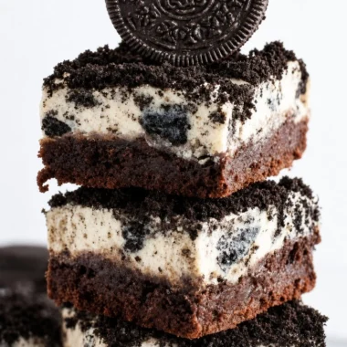 Brownie bottom Oreo cheesecake bars topped with cookie crumbles