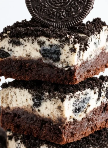 Brownie bottom Oreo cheesecake bars topped with cookie crumbles