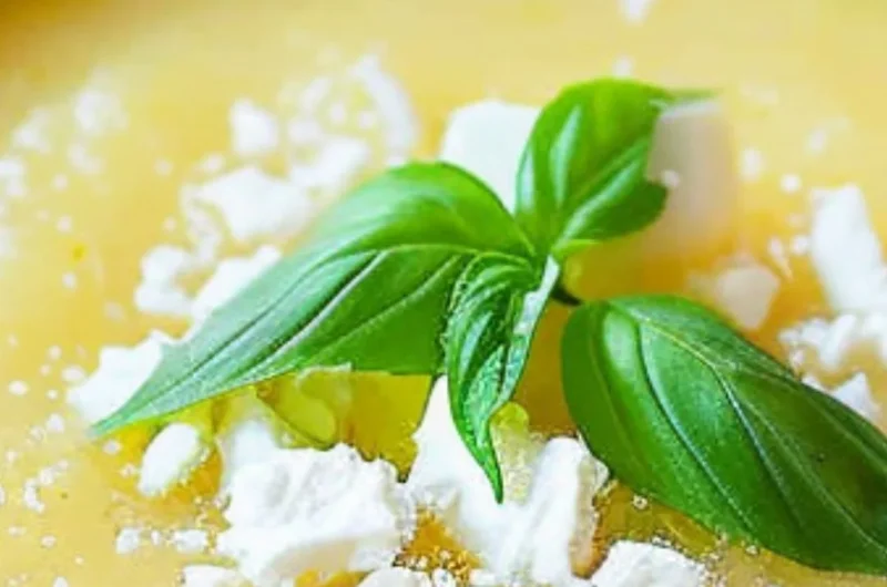 A refreshing bowl of chilled pineapple soup garnished with mint leaves.