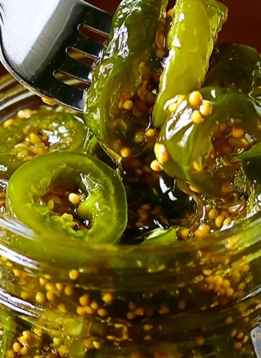 Jar of homemade Cowboy Candy with jalapeños and syrup