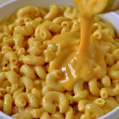 Creamy vegan mac & cheese without cashews in a bowl, garnished with herbs.