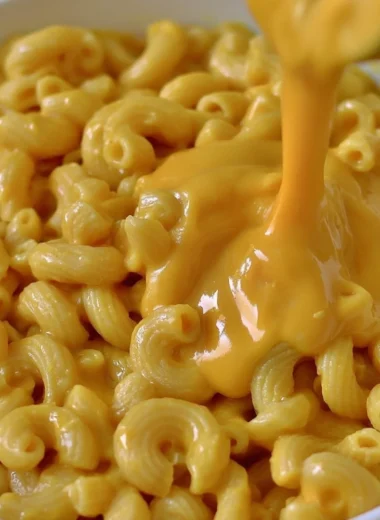 Creamy vegan mac & cheese without cashews in a bowl, garnished with herbs.