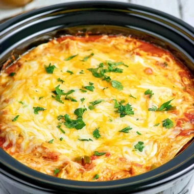 Crockpot Chicken Enchilada Casserole topped with cheese and fresh toppings