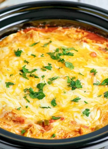 Crockpot Chicken Enchilada Casserole topped with cheese and fresh toppings