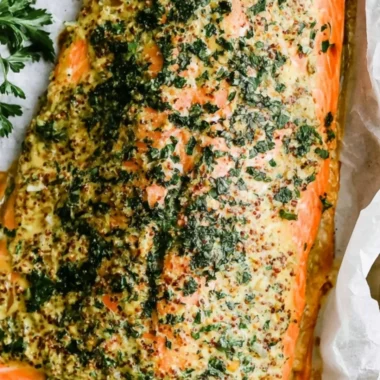 Plate of Dijon Baked Salmon garnished with herbs and lemon slices