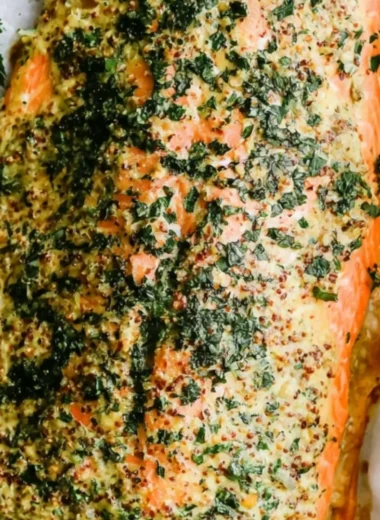 Plate of Dijon Baked Salmon garnished with herbs and lemon slices