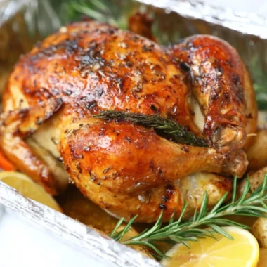 Garlic lemon roasted chicken served on a platter with herbs.