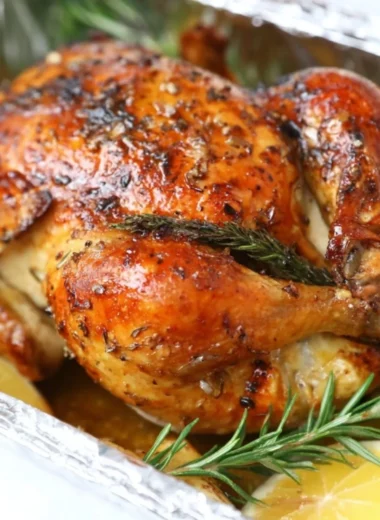 Garlic lemon roasted chicken served on a platter with herbs.