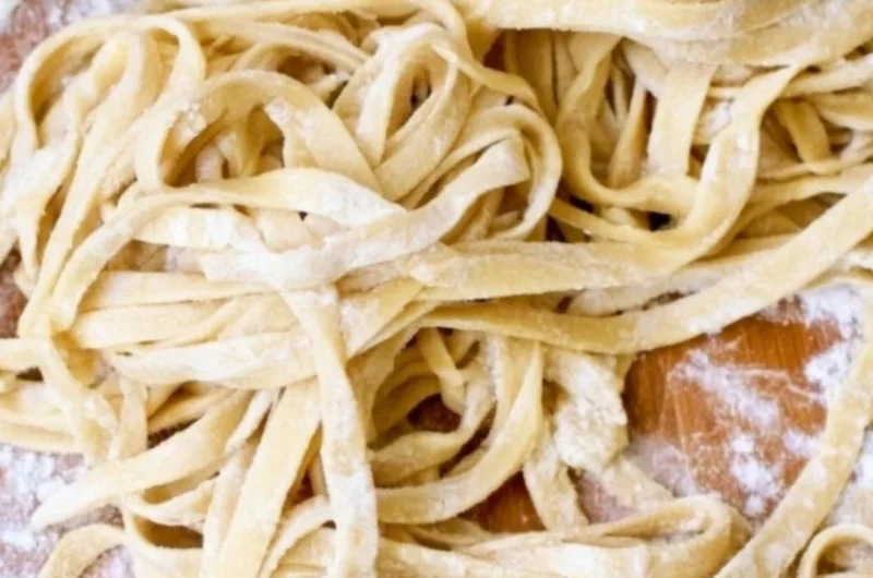 Bowl of homemade egg noodles ready for cooking in a delicious broth.