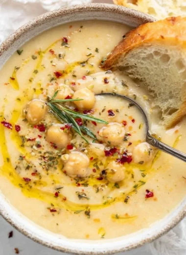Vegan garlic chickpea soup garnished with herbs in a bowl
