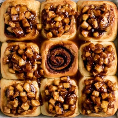 Delicious apple pie cinnamon rolls topped with icing and cinnamon.