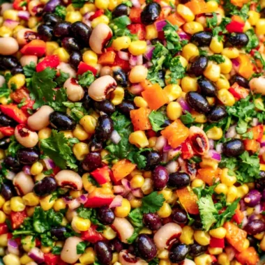 Colorful bowl of cowboy caviar salad with beans, tomatoes, and spices.