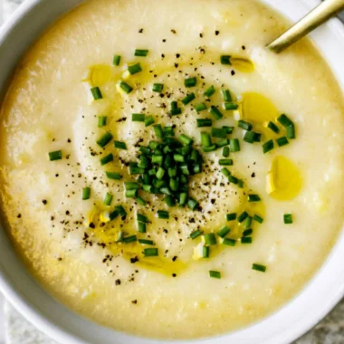 Bowl of creamy potato leek soup with fresh herbs and a drizzle of olive oil