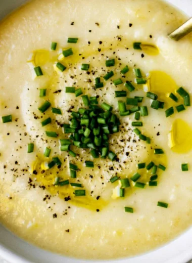 Bowl of creamy potato leek soup with fresh herbs and a drizzle of olive oil