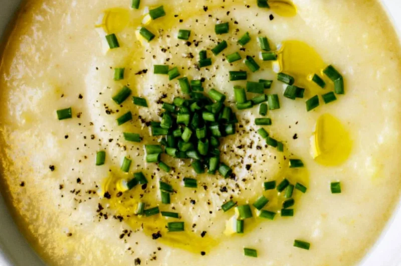 Bowl of creamy potato leek soup with fresh herbs and a drizzle of olive oil