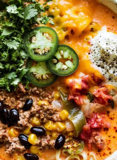 Bowl of creamy taco soup with toppings like cheese and avocado