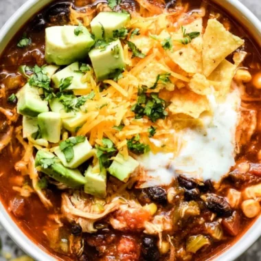 Delicious bowl of Crockpot Chicken Enchilada Soup topped with cheese and cilantro