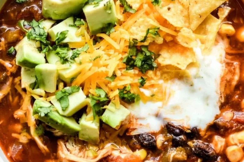 Delicious bowl of Crockpot Chicken Enchilada Soup topped with cheese and cilantro