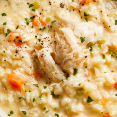 Creamy chicken rice soup in a bowl with fresh herbs and vegetables