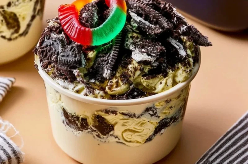 Delicious homemade dirt pudding dessert served in a clear cup with gummy worms.