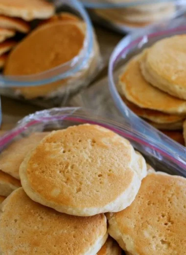 A stack of easy freezer pancakes served with syrup and berries.