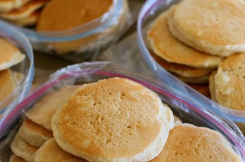 A stack of easy freezer pancakes served with syrup and berries.