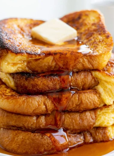 Delicious slice of easy French toast topped with syrup and berries