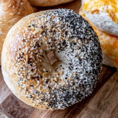 Freshly baked easy sourdough bagels on a wooden board