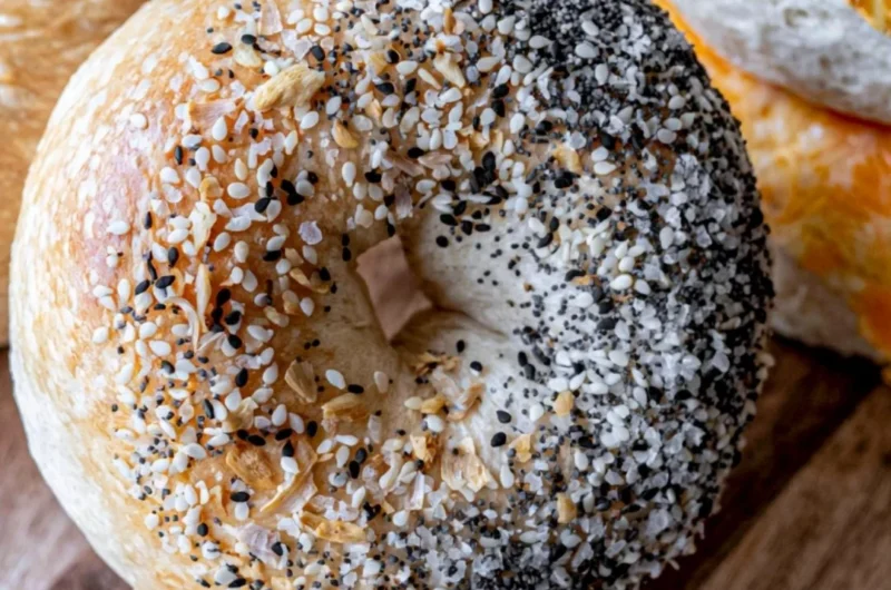 Freshly baked easy sourdough bagels on a wooden board