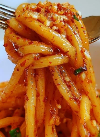 Bowl of Garlic Chili Oil Noodles topped with fresh herbs and spices