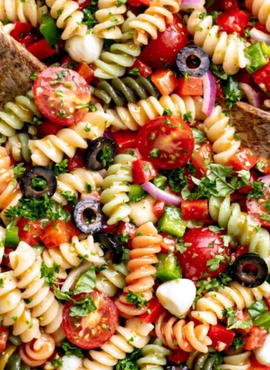 Bowl of Italian pasta salad with colorful vegetables and dressing