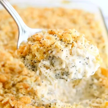 Poppy Seed Chicken Casserole served in a baking dish with fresh herbs