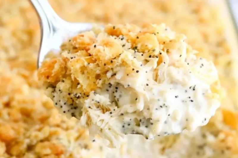 Poppy Seed Chicken Casserole served in a baking dish with fresh herbs