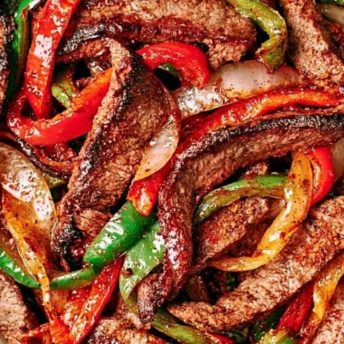 Delicious steak fajitas served with peppers and onions on a plate