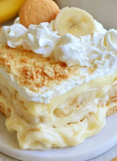 Delicious banana pudding served in a bowl with fresh bananas on top.