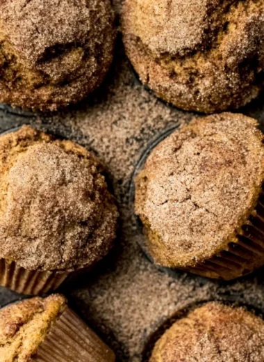 Pumpkin Snickerdoodle Muffins with cinnamon sugar on a wooden table