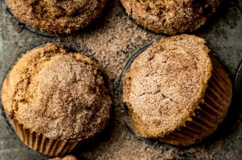 Pumpkin Snickerdoodle Muffins with cinnamon sugar on a wooden table