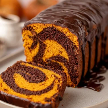 Vegan Pumpkin Marble Cake beautifully sliced with decorative pumpkin garnish.
