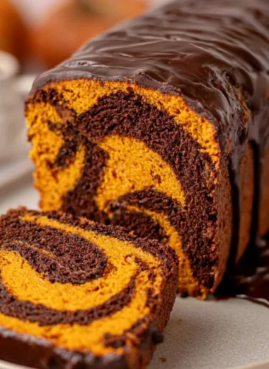 Vegan Pumpkin Marble Cake beautifully sliced with decorative pumpkin garnish.