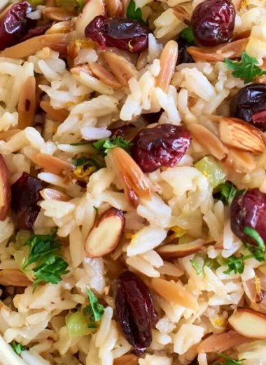 Delicious Cranberry Rice Pilaf served on a plate with fresh herbs