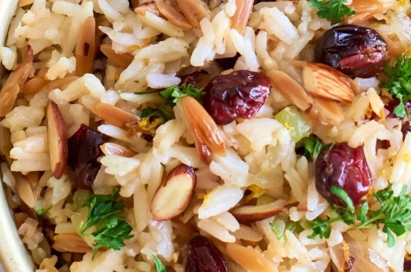 Delicious Cranberry Rice Pilaf served on a plate with fresh herbs